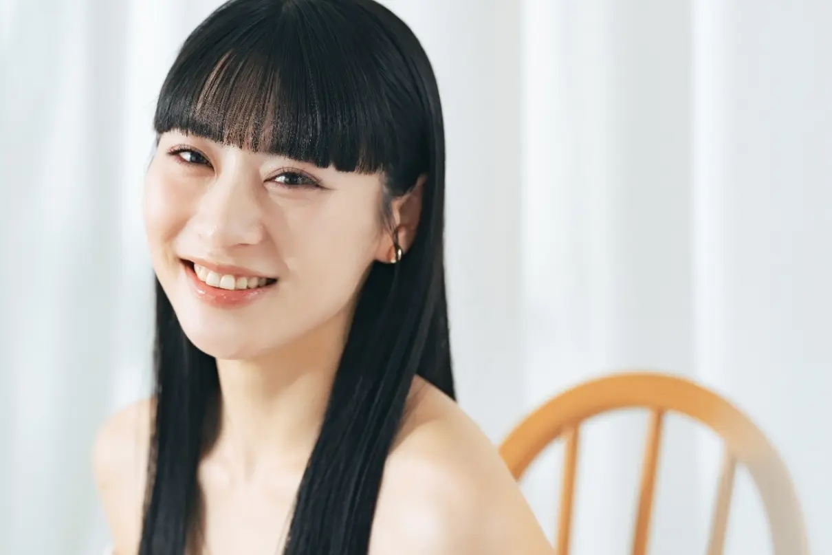 黒髪でぱっつん前髪の笑顔の女性