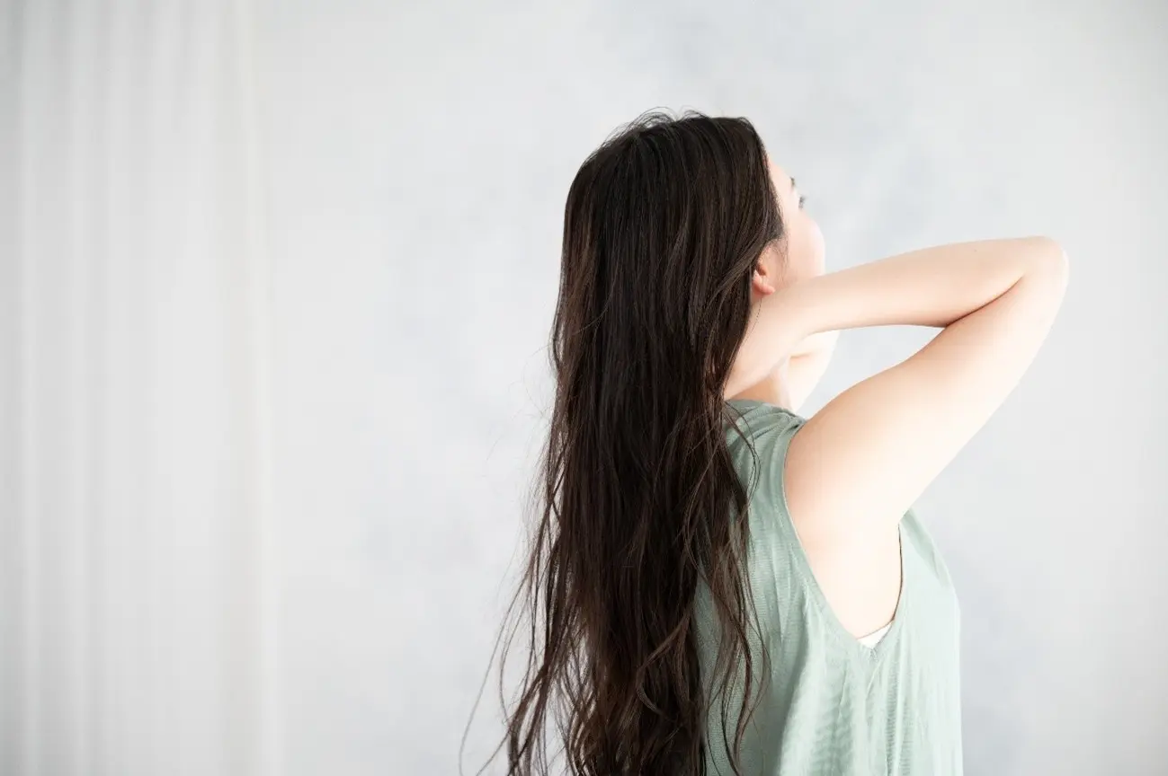 後ろを向く髪の長い女性