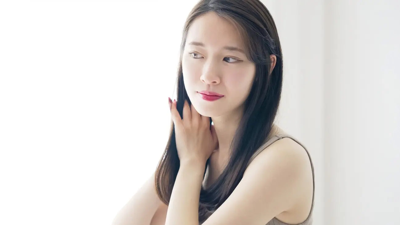 髪を手でなでるセミロングの女性