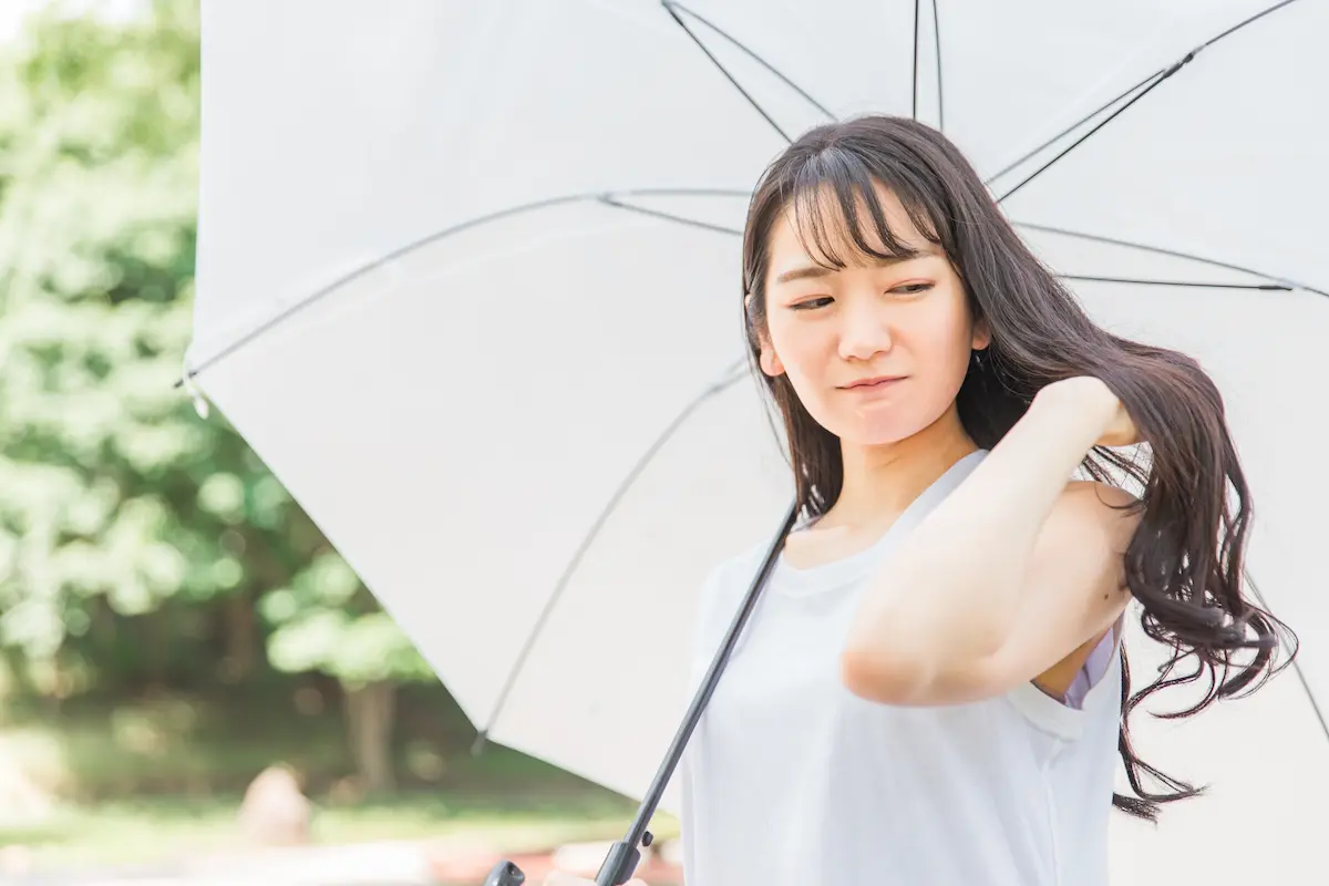 日傘をさす髪の長い女性