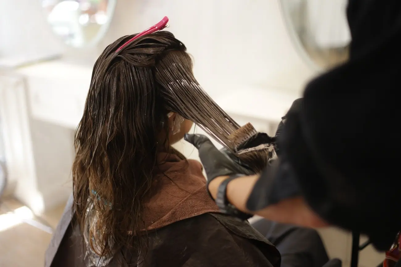 美容院でヘアカラーをする女性