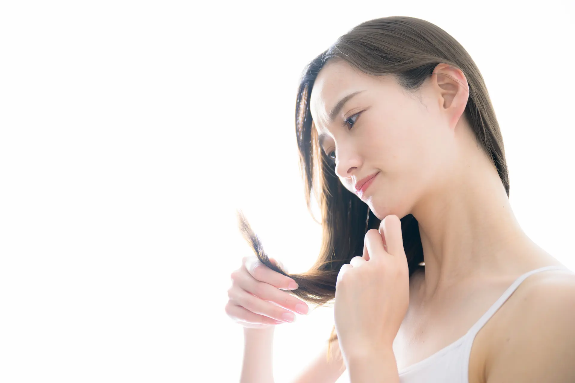 毛先を見つめる女性の横顔