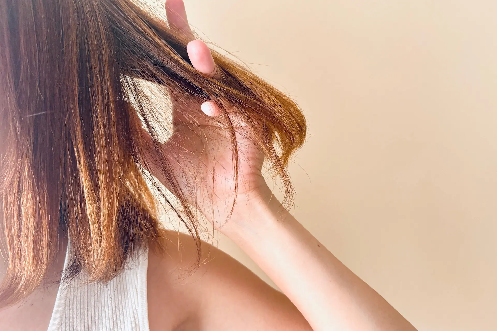 髪を手でとかす女性