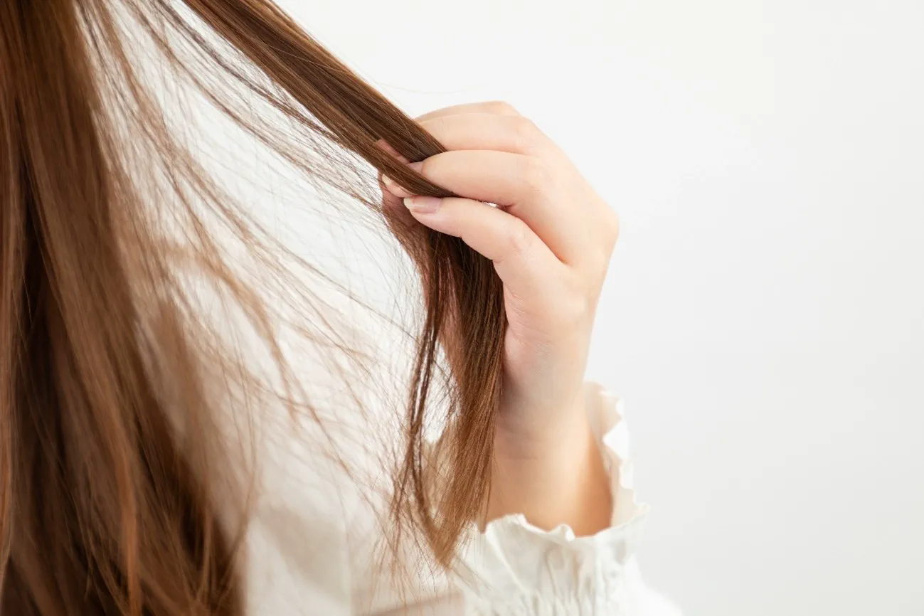 髪を触る女性の手元