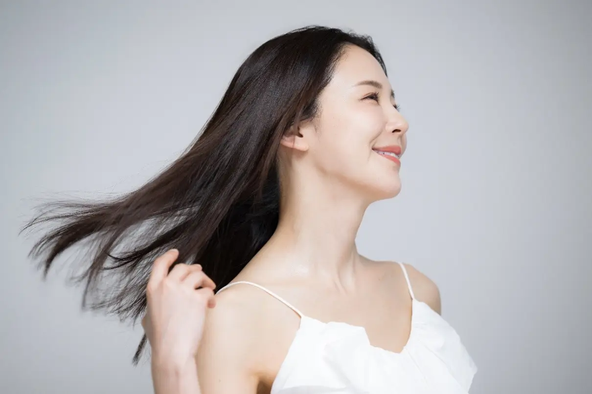 美しいロングヘアをなびかせる女性の横顔