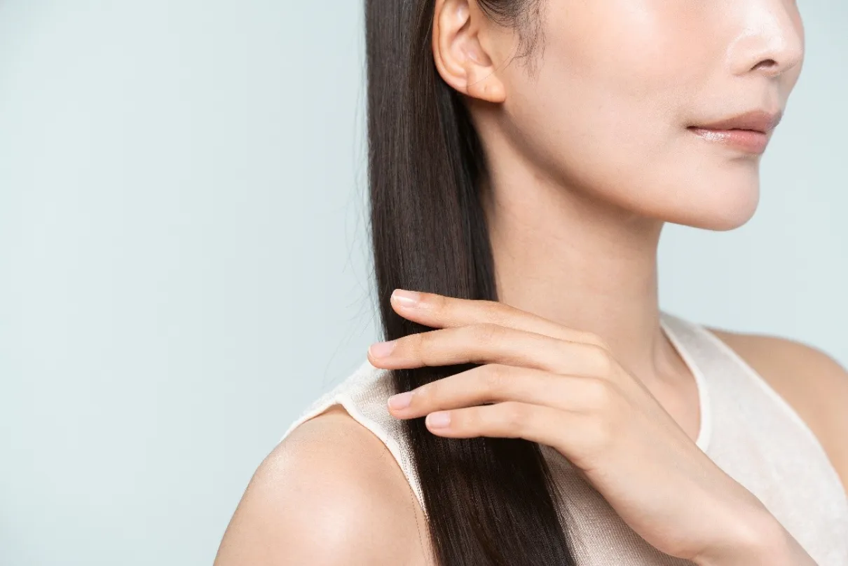 ロングヘアの美しい髪を手でなでる女性