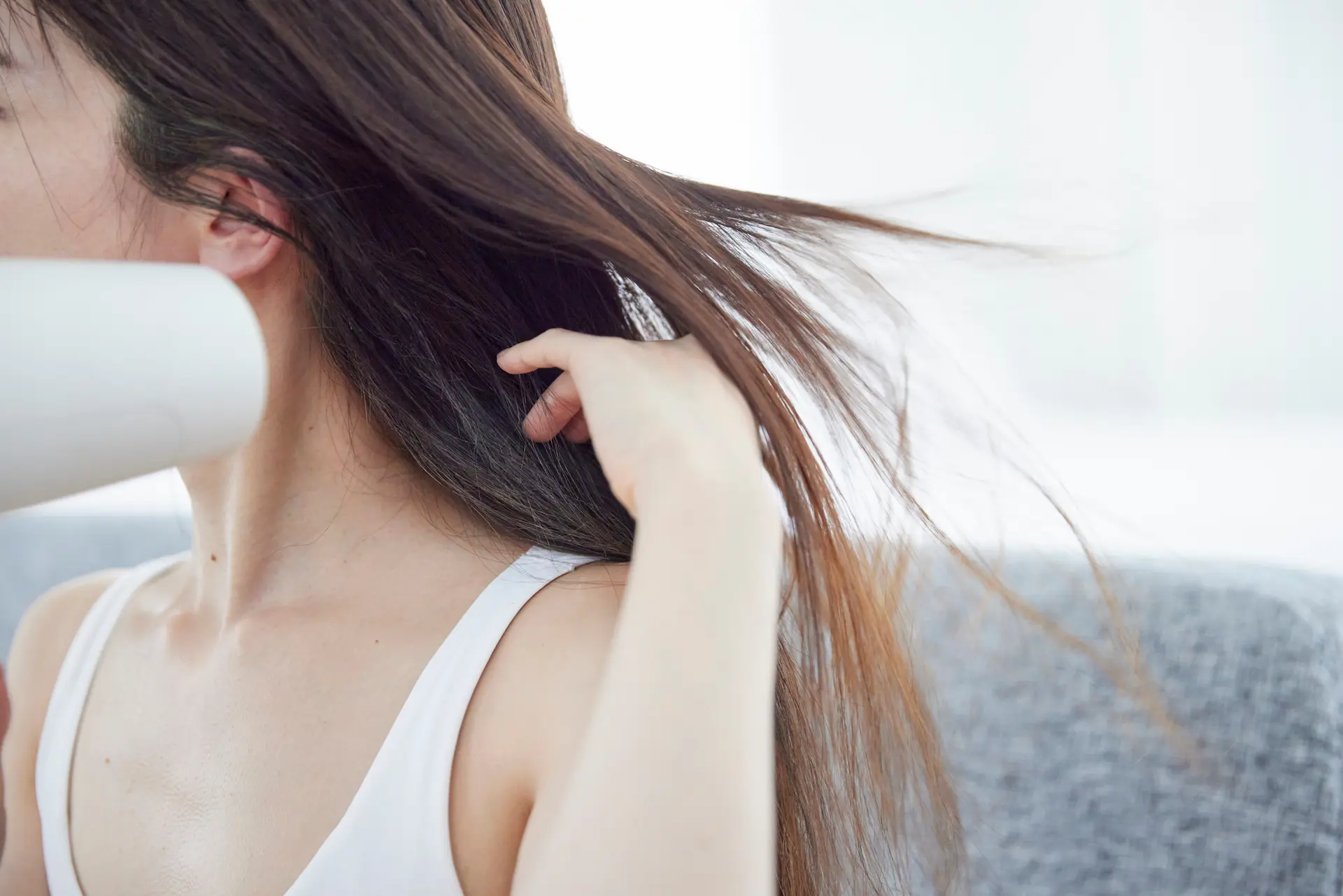 ドライヤーで髪を乾かす髪の長い女性