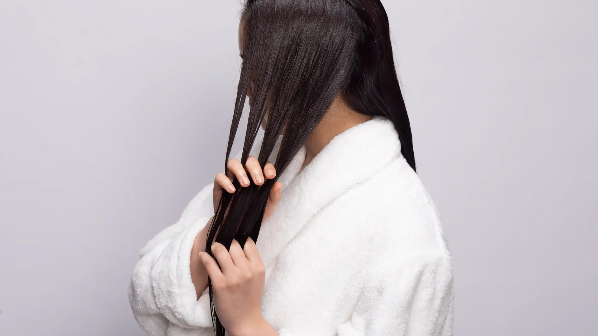 髪を手ぐしでとかす女性の横からの姿の画像