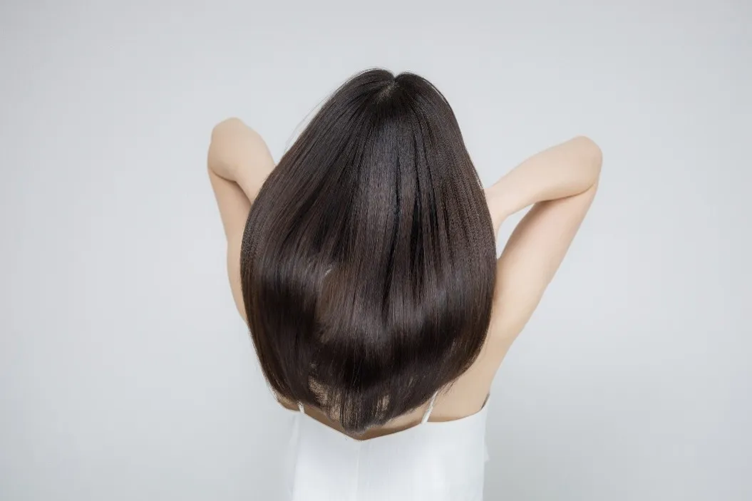 美しい髪をなびかせる女性の後ろ姿