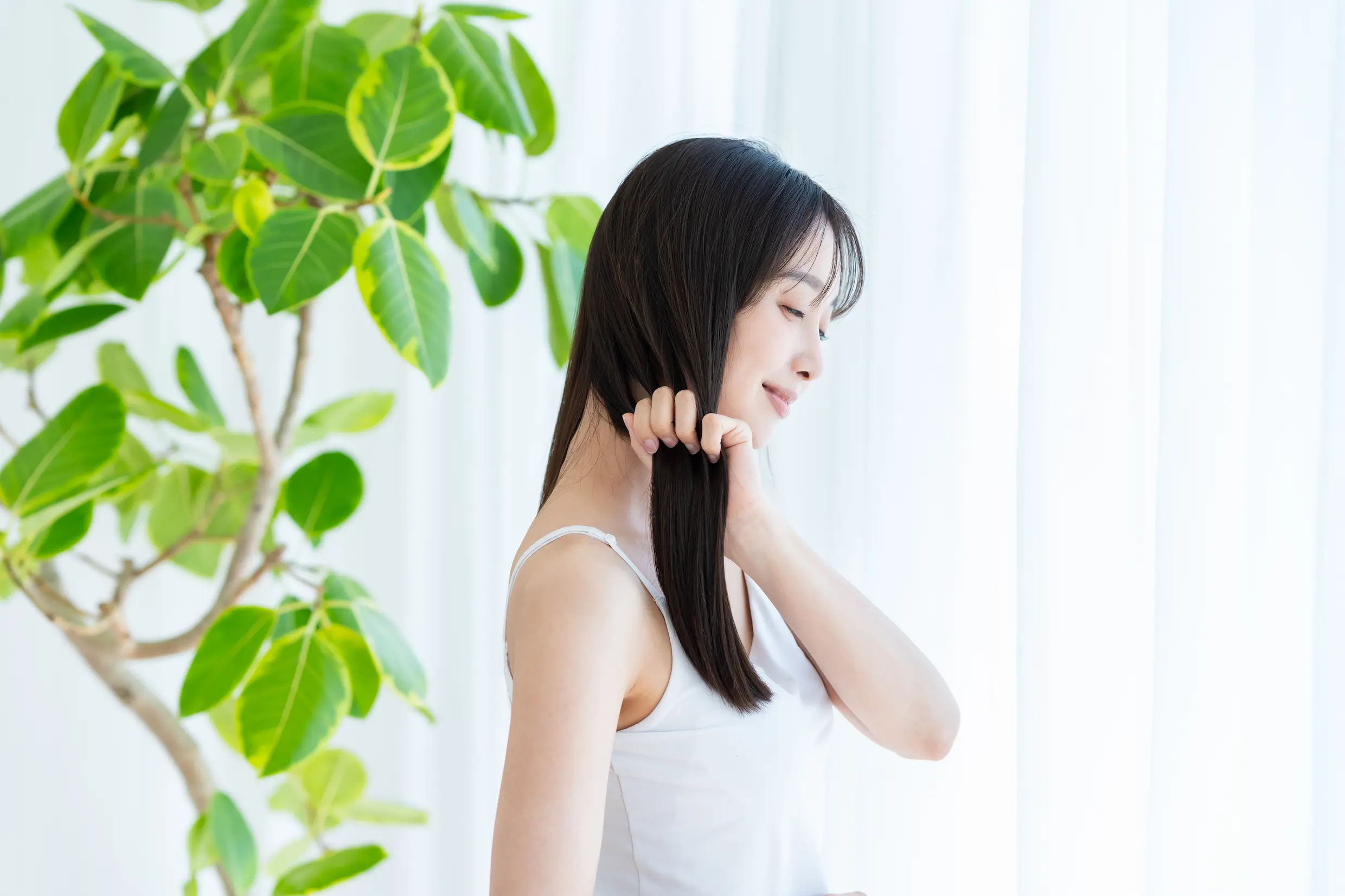 手ぐしで髪の毛をとかす女性の姿