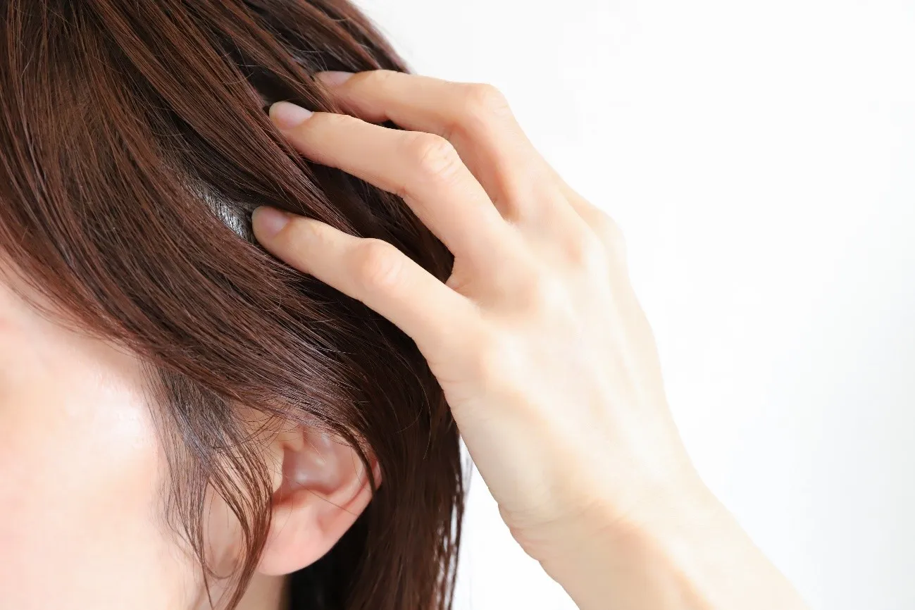頭皮を指で押さえてチェックする女性