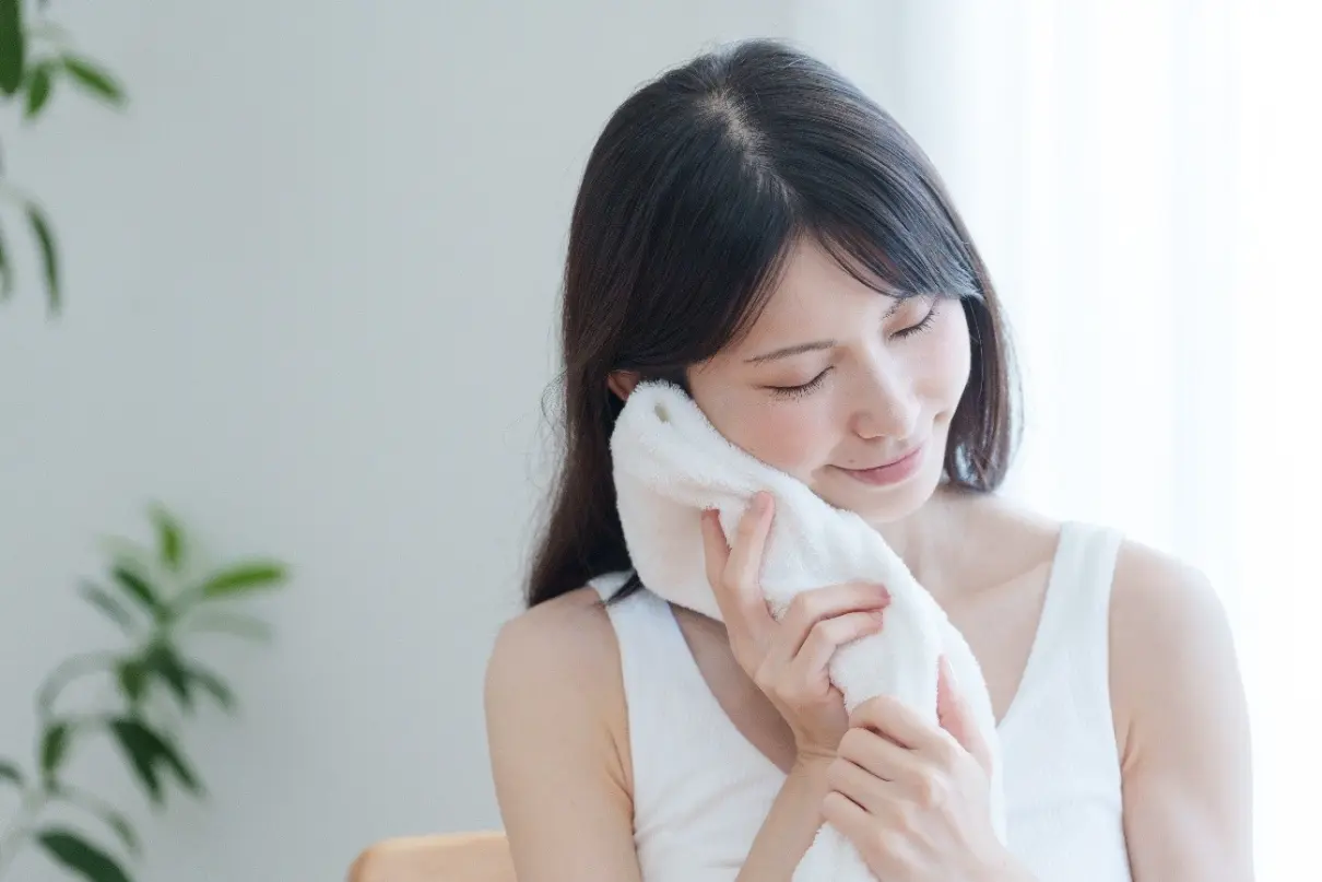 タオルを肌に優しく当てる女性