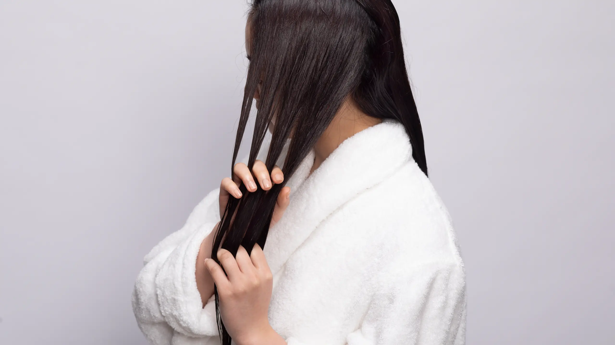 髪を手でとかす横向きの女性の画像