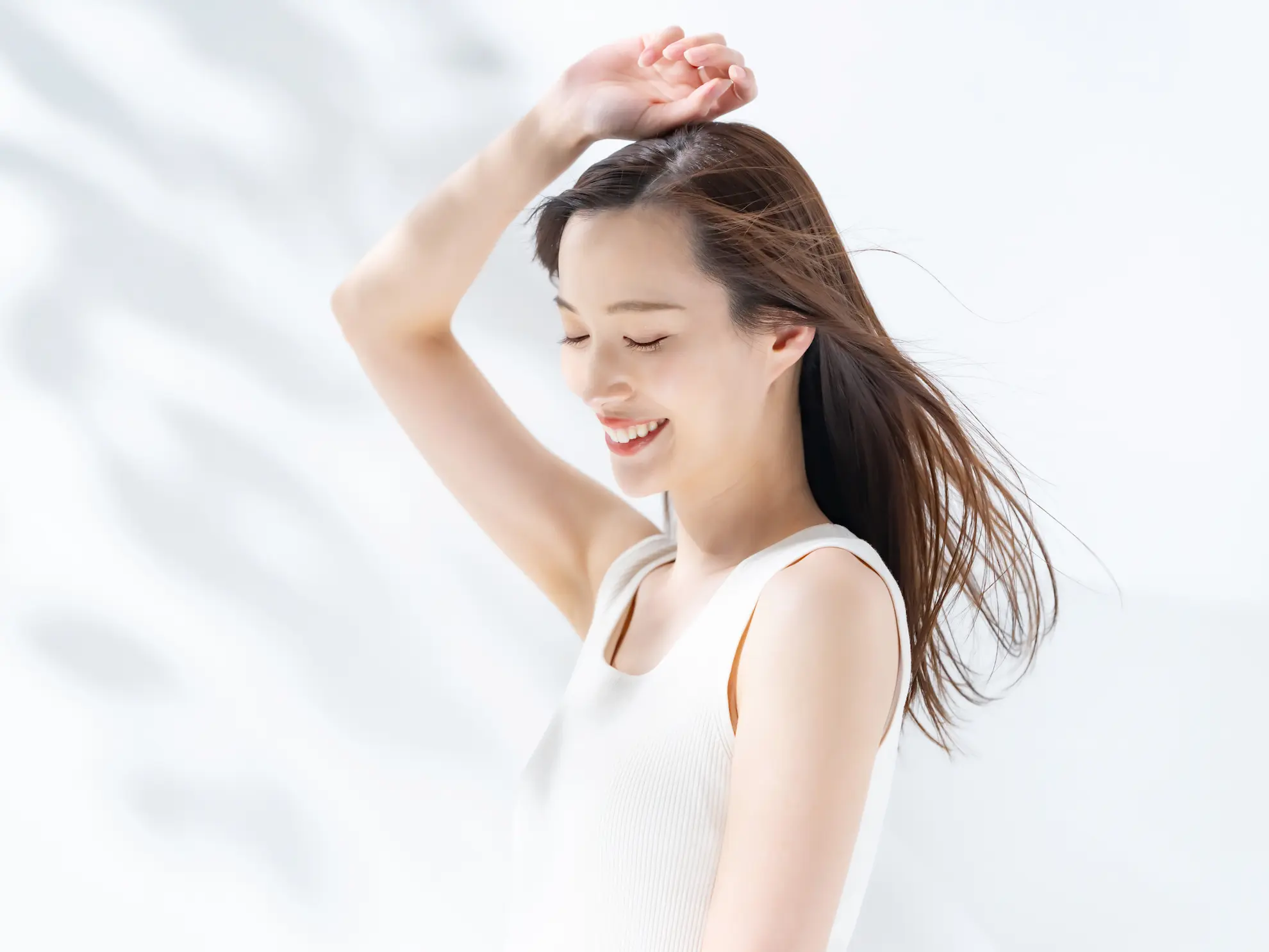 風になびいて微笑む女性の画像