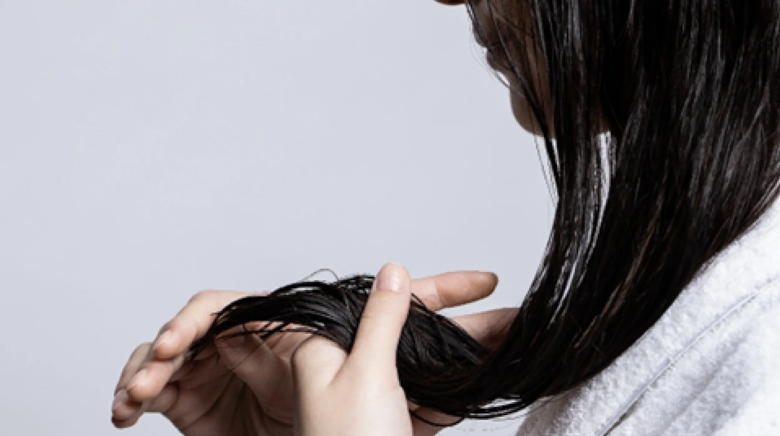 毛先を見つめる女性の横顔