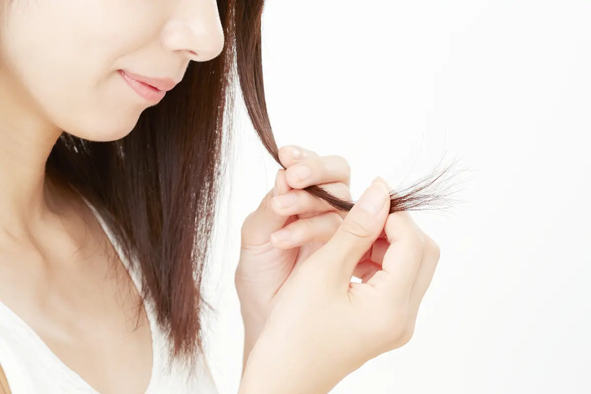 毛先の束を見つめる女性