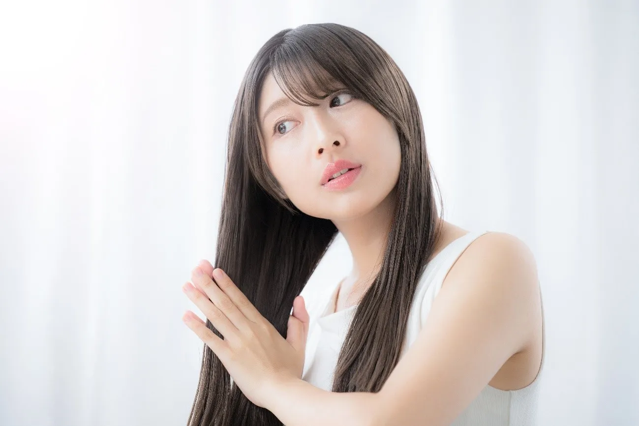 ツヤのある直毛の髪に触れる女性