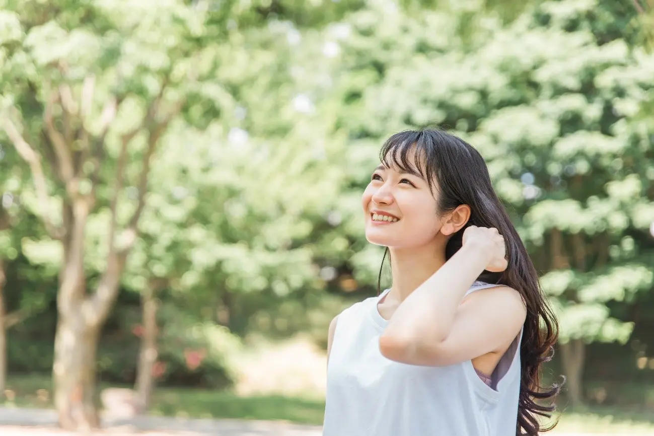 屋外いる笑顔のロングヘアの女性