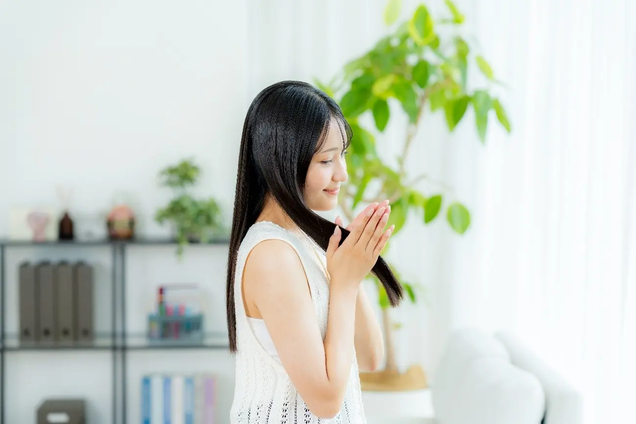 手で髪を触る美しいロングヘアの女性